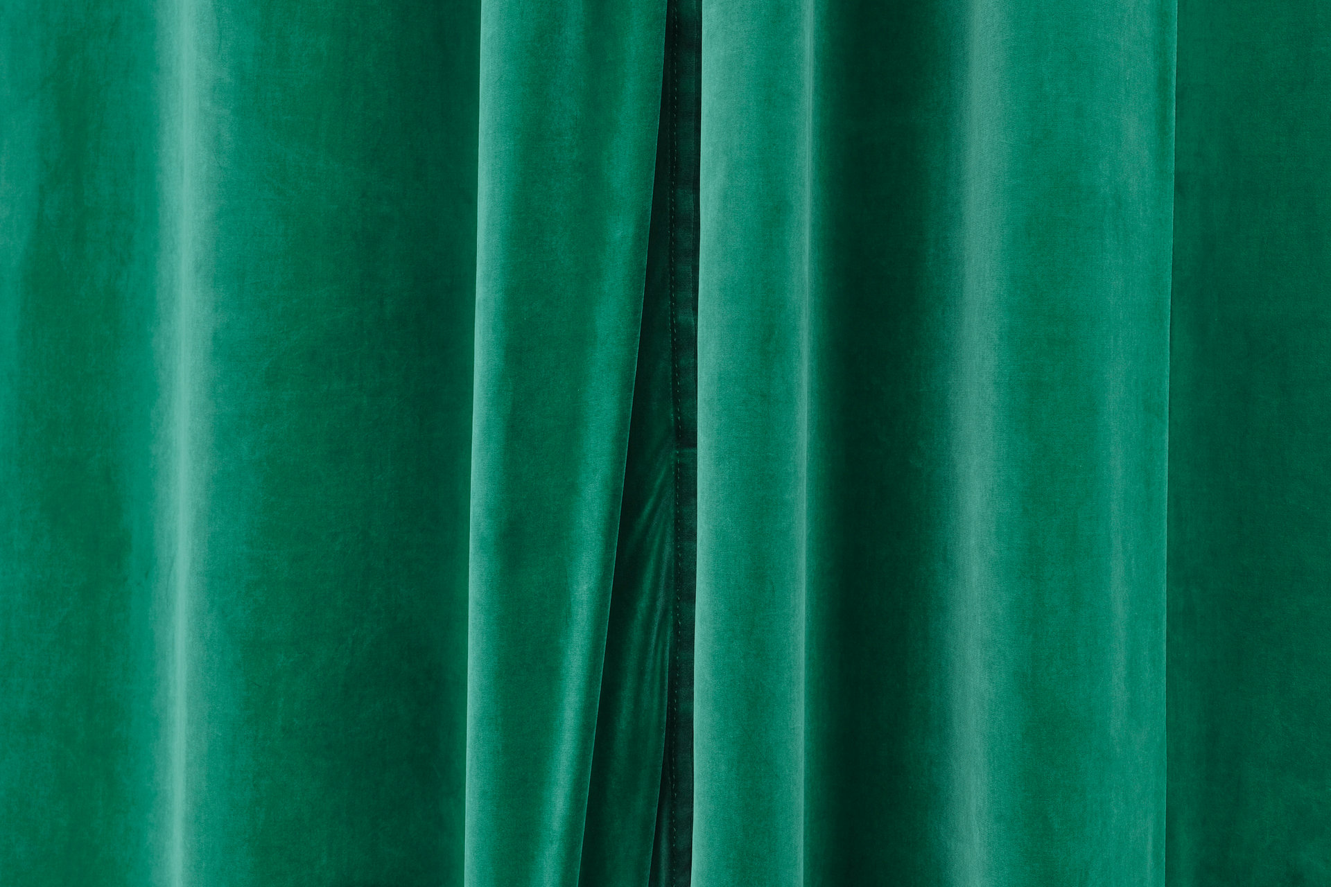 Closed green velvet stage curtain.